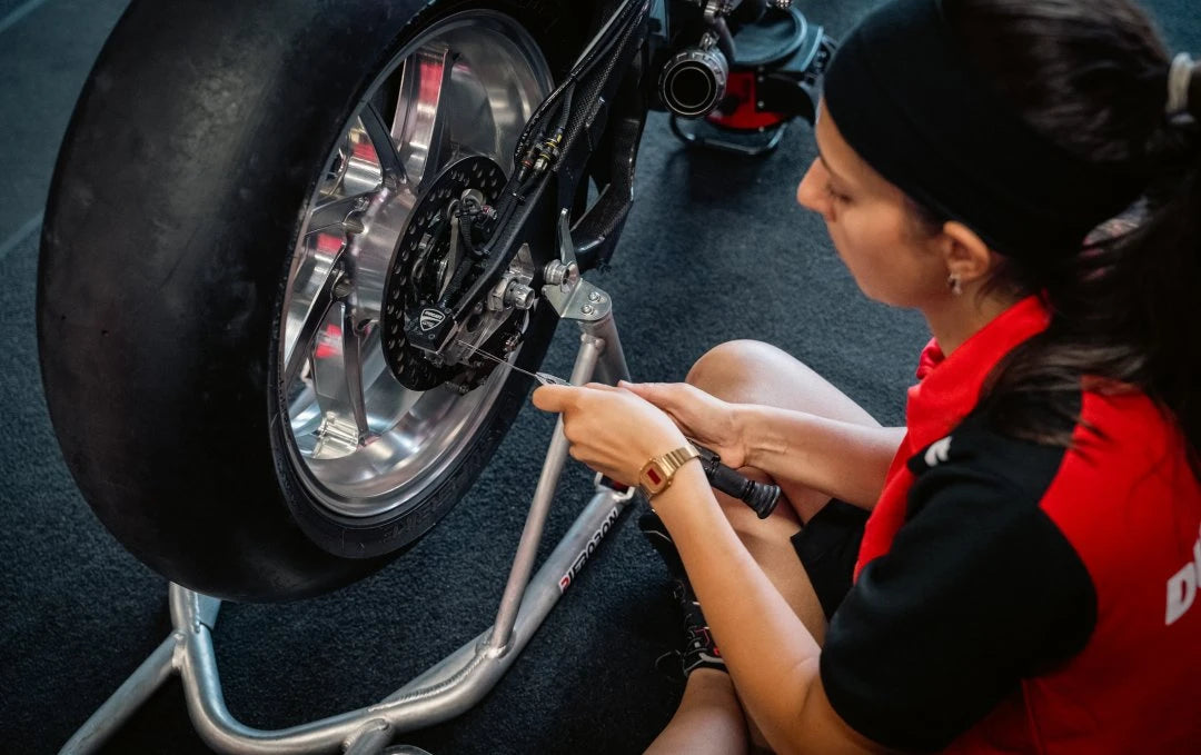 A Ducati team member working on a Panigale front wheel during testing at Misano