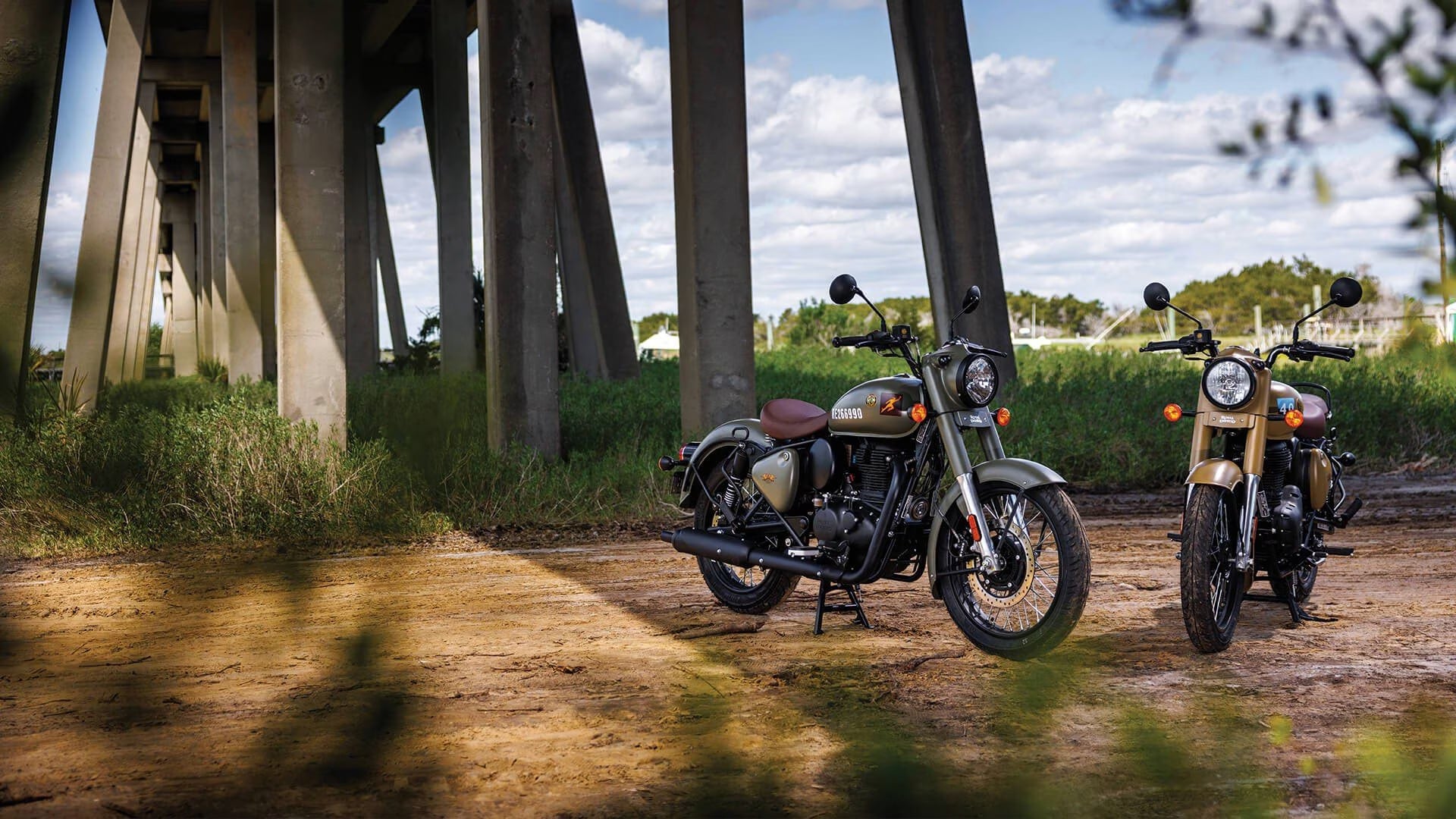 Royal Enfield motorcycles under a bridge